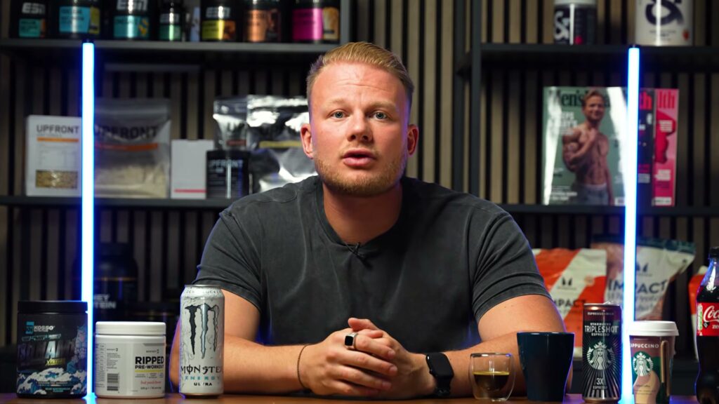 Red Hooftman aan tafel met koffie, energiedrank en pre-workout in onze video over cafeïne