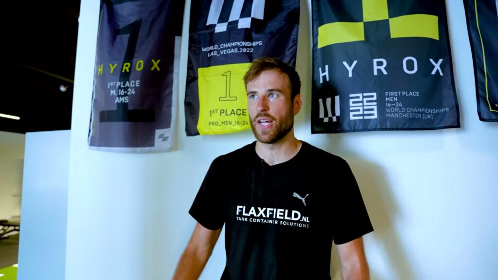 HYROX-atleet Hidde Weersma voor zijn vlaggen van de wereldkampioenschappen in Las Vegas en Manchester